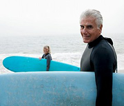 Older couple holding their surfboards in front of ocean. - Copyright – Stock Photo / Register Mark