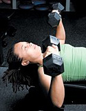 Chelsea Cooper performing flat bench dumbbell chest press. - Copyright – Stock Photo / Register Mark